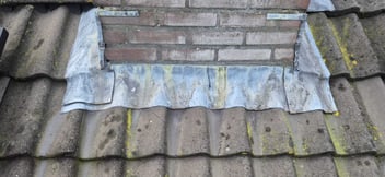 Slijtage aan loodwerk rond schoorsteen